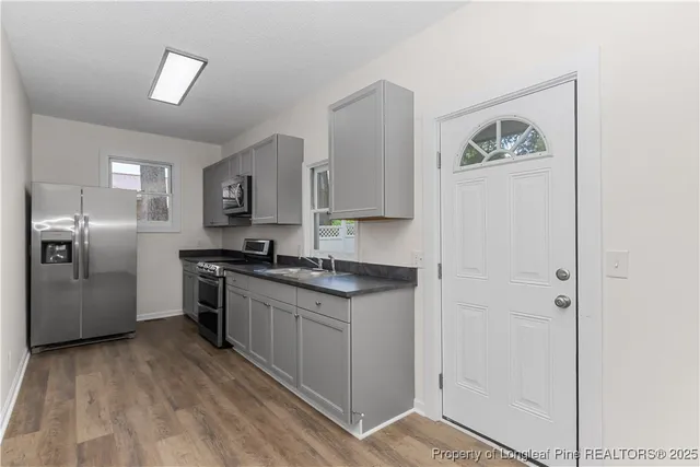a kitchen with stainless steel appliances granite countertop a refrigerator and a stove