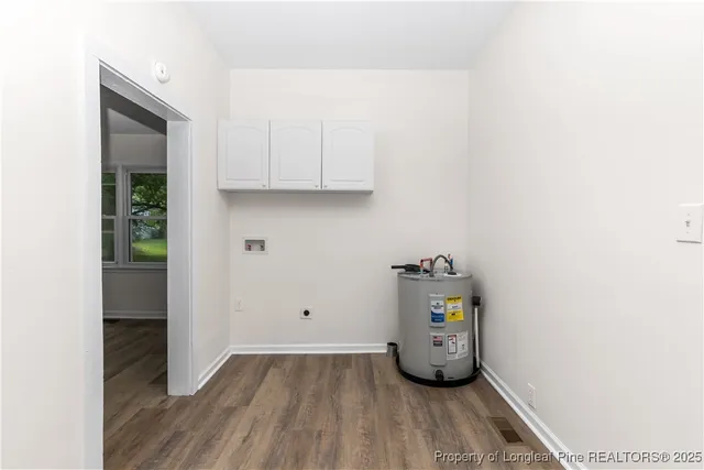 a view of an empty room with wooden floor and closet