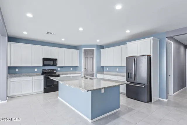 a modern kitchen with stainless steel appliances granite countertop a refrigerator and a stove top oven
