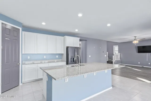 a kitchen with a sink refrigerator and cabinets