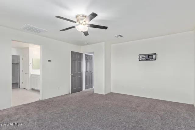 an empty room with windows and fan