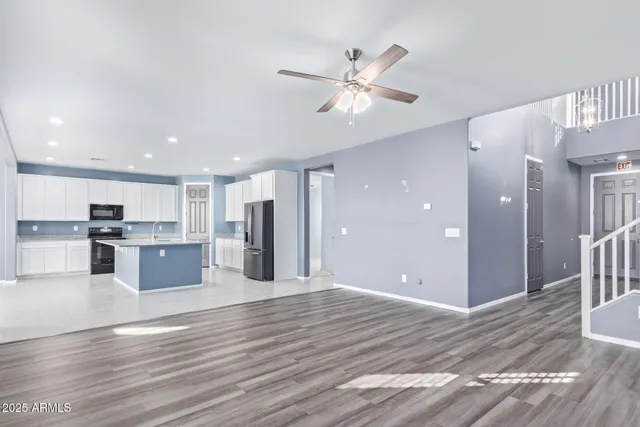 a view of kitchen with refrigerator and white wooden cabinets