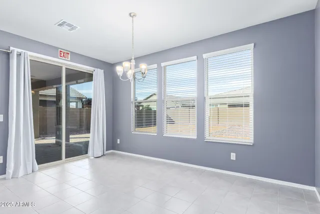 a view of an empty room with glass door and windows