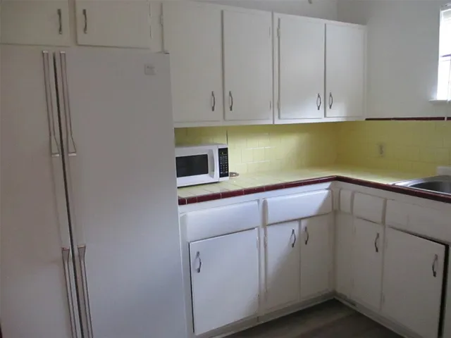 a kitchen with white cabinets and white appliances