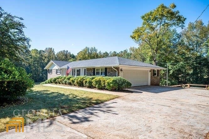 300 Rosser Road Covington, GA 30016 - Photo 1 of 1 a front view of a house with a yard and garage