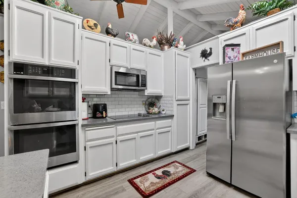 a kitchen with stainless steel appliances a refrigerator sink and microwave