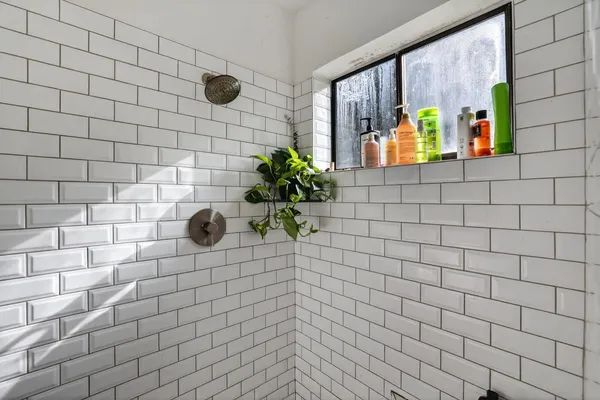 a bathroom with a granite countertop sink a mirror and shower