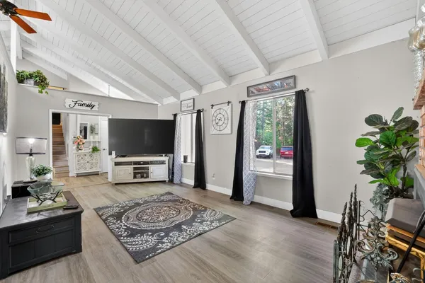 a dining room with furniture a chandelier and wooden floor