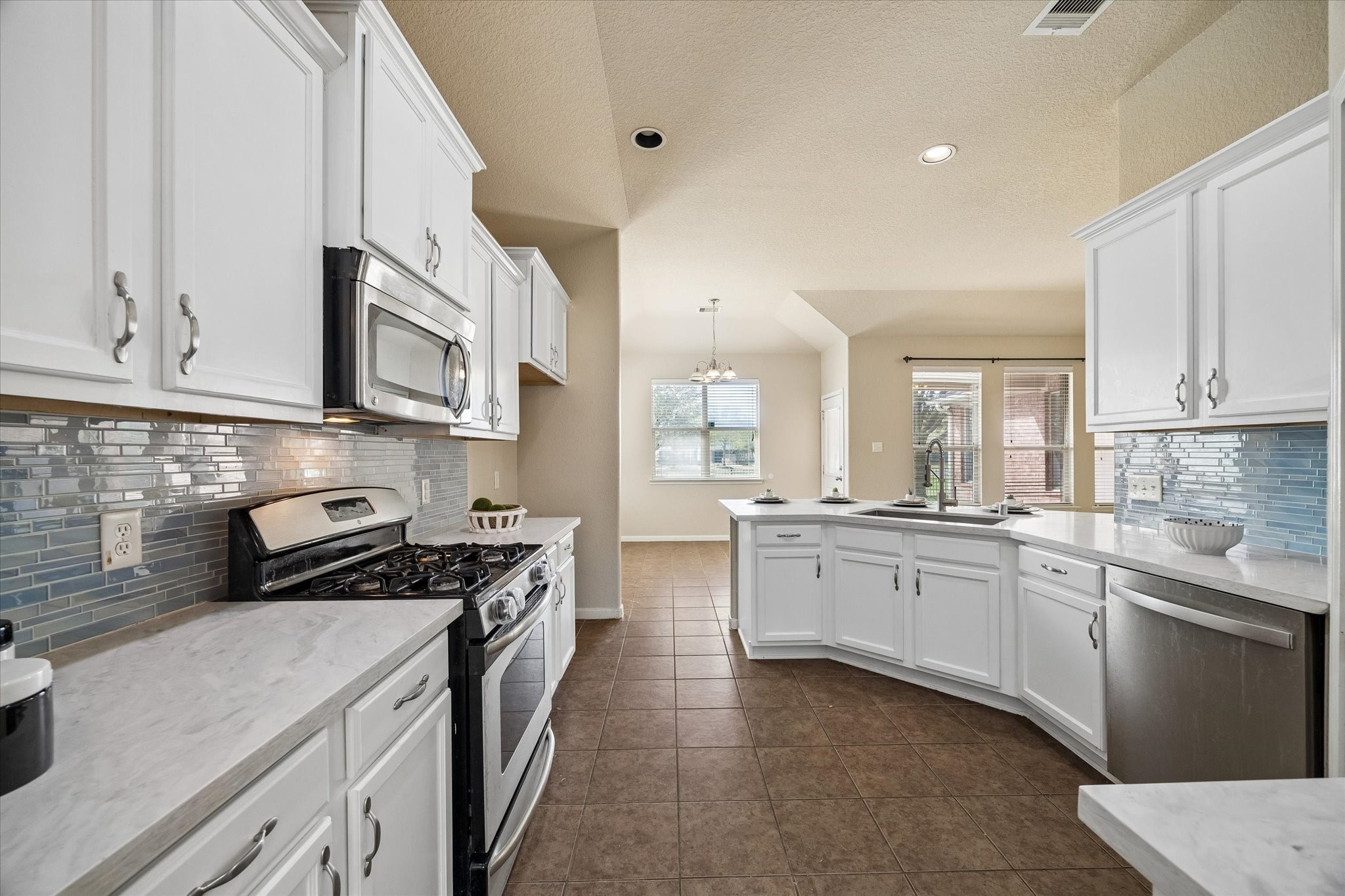 7806 Summer Night Lane Rosenberg, TX 77469 - Photo 7 of 23 Tile flooring runs throughout the kitchen, connecting the cooking area to the breakfast space and back entry while providing extended counter space and a clear path toward the breakfast area.