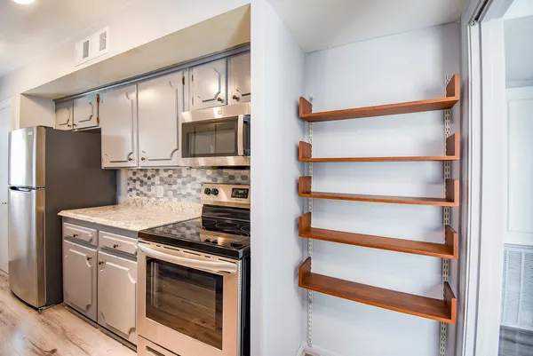 a kitchen with granite countertop stainless steel appliances and wooden cabinets