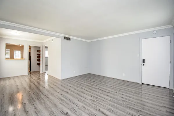 a view of an empty room with wooden floor
