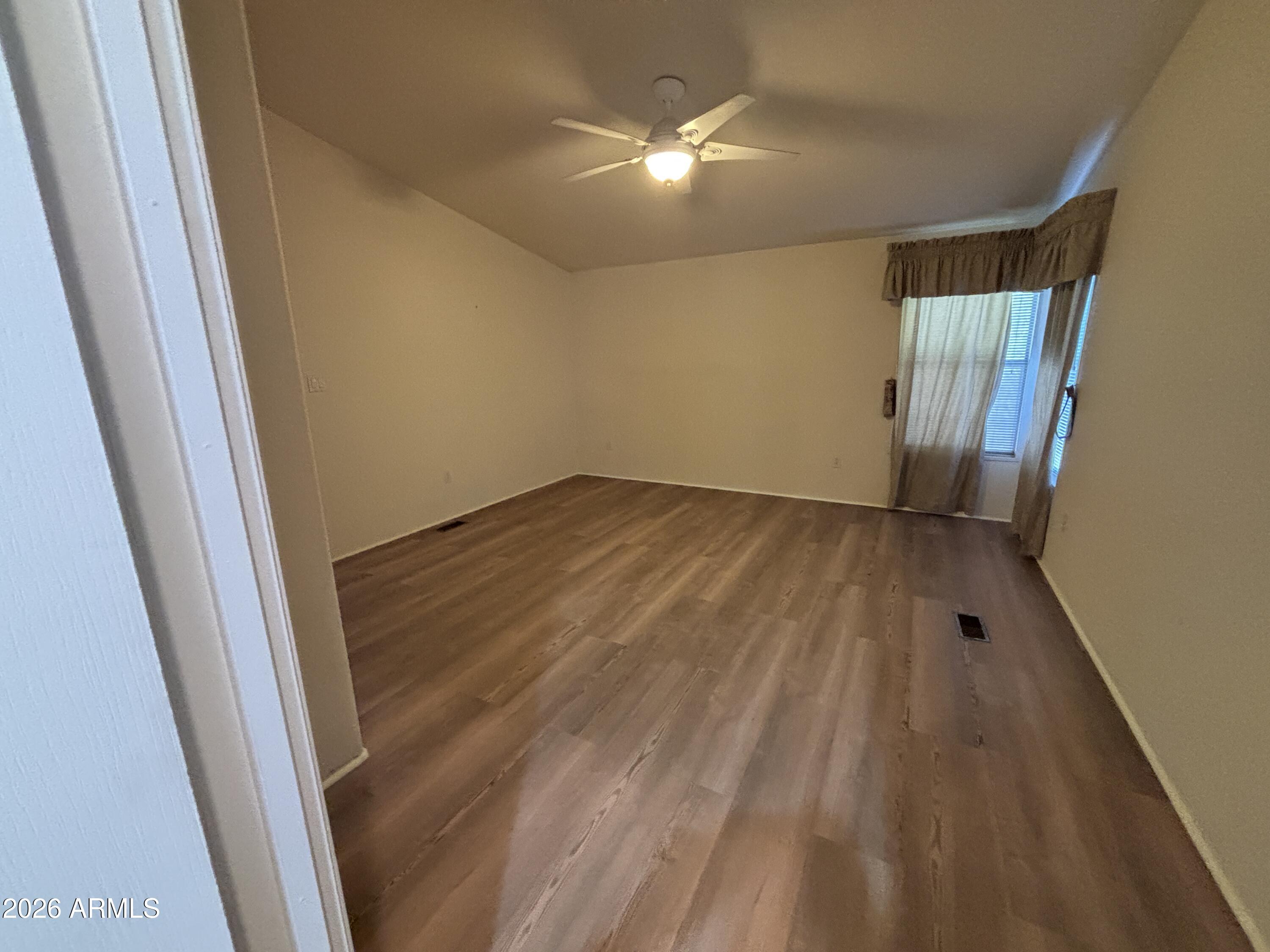 3355 South Cortez Road, Unit 28 Apache Junction, AZ 85119 - Photo 10 of 24 en empty room with wooden floor and fan