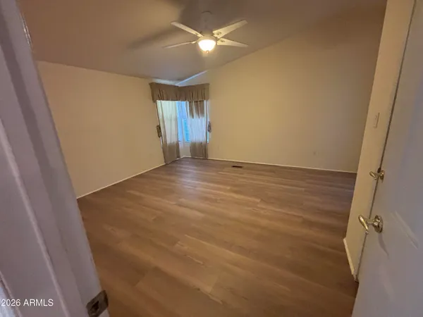 a view of an empty room with closet and a window