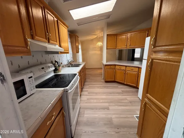 a kitchen with a sink a stove top oven a refrigerator and cabinets