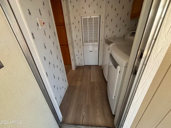 a view of a hallway with wooden floor and stairs