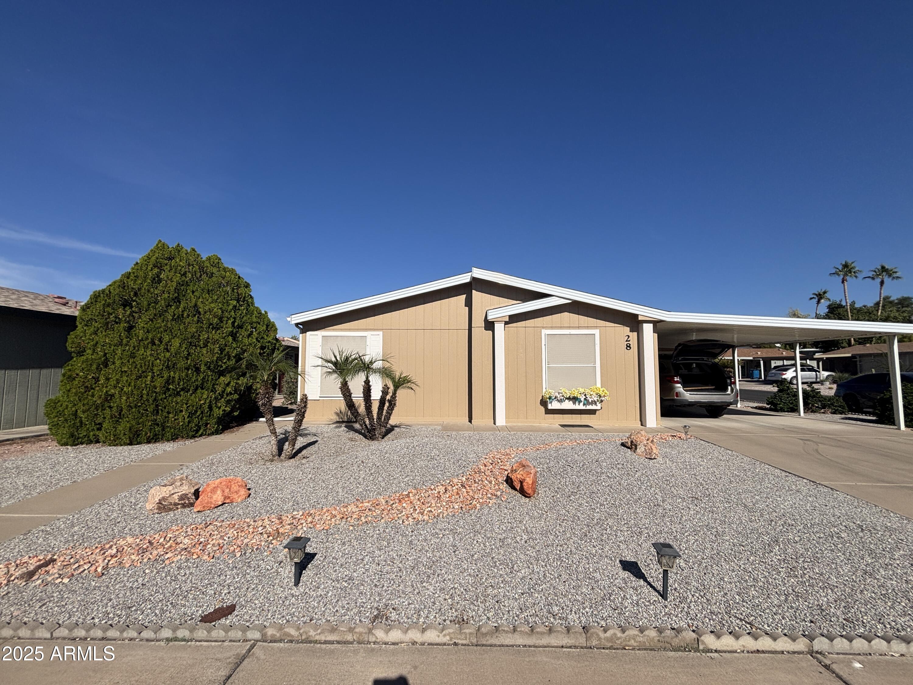 3355 South Cortez Road, Unit 28 Apache Junction, AZ 85119 - Photo 2 of 24 a front view of a house with a yard