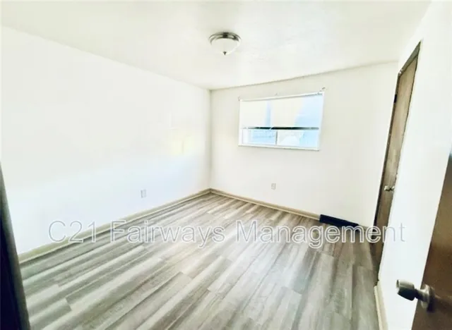a view of a room with wooden floor and a window