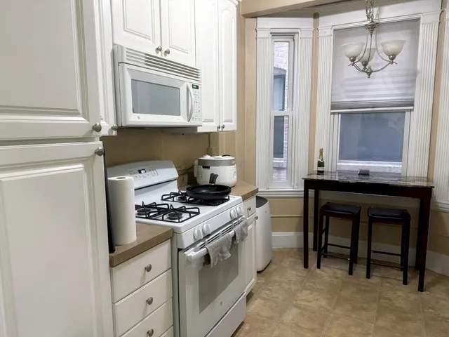 a kitchen with granite countertop cabinets stainless steel appliances and a wooden floor