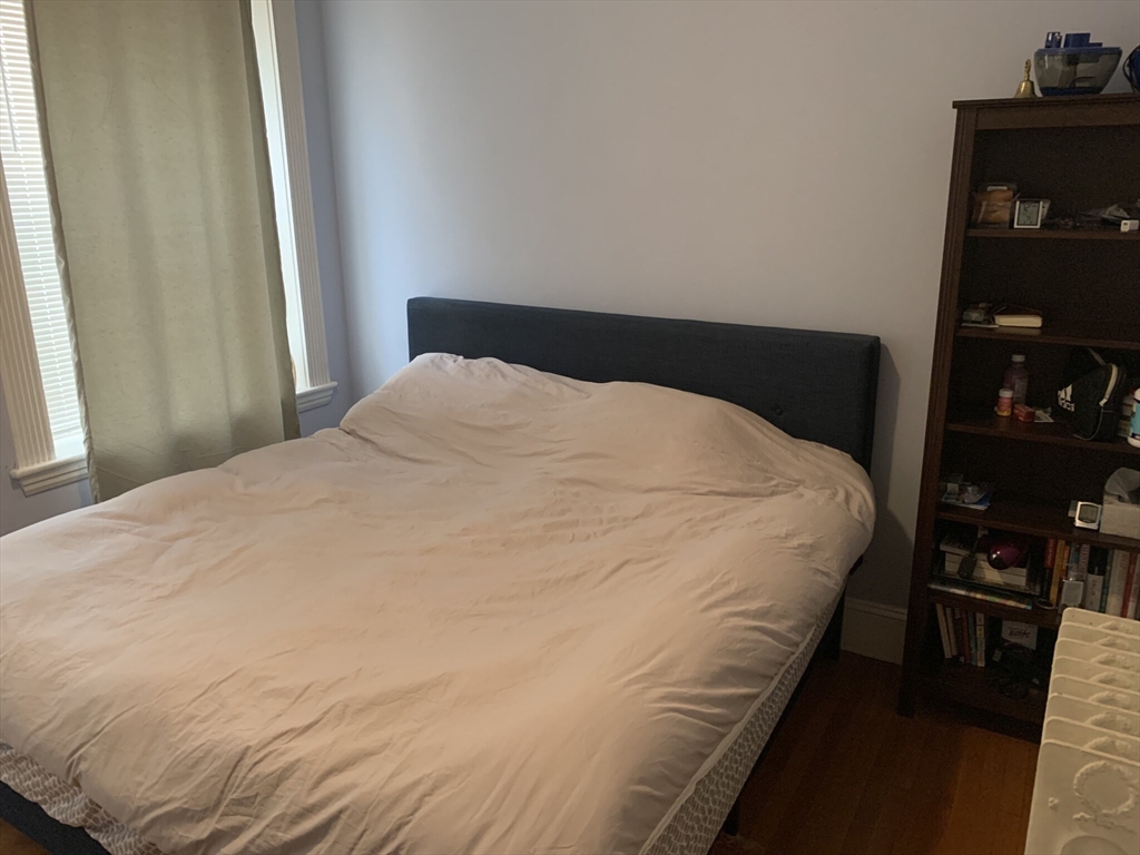 8 Garrison Street, Unit 511 Boston, MA 02116 - Photo 8 of 13 a large bed sitting in a bedroom next to a window