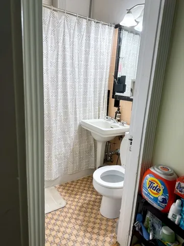a bathroom with a toilet a sink and a shower