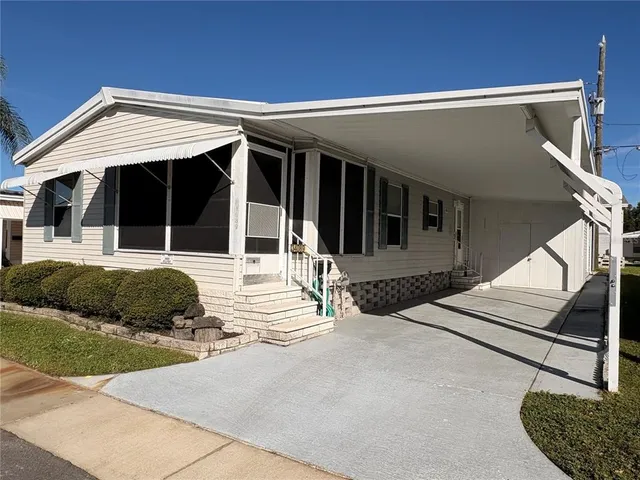 a view of a house with backyard and parking
