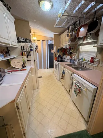 a kitchen with stainless steel appliances granite countertop a sink a stove and a wooden cabinets