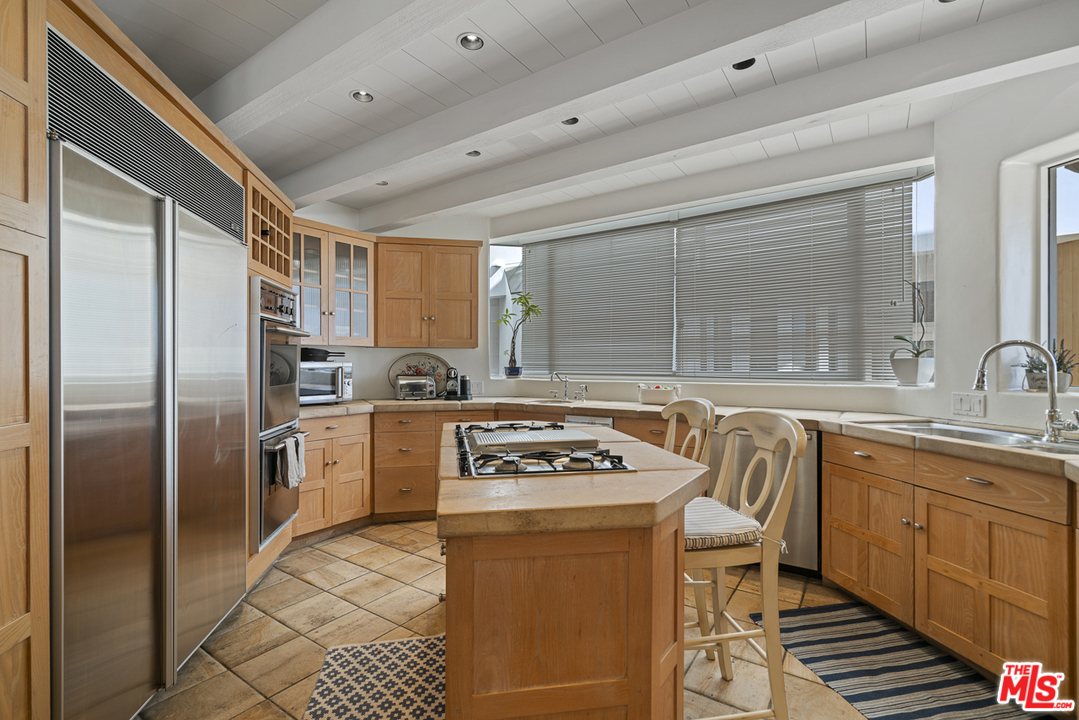 31725 Sea Level Drive Malibu, CA 90265 - Photo 15 of 37 a kitchen with stainless steel appliances a stove a sink refrigerator and cabinets