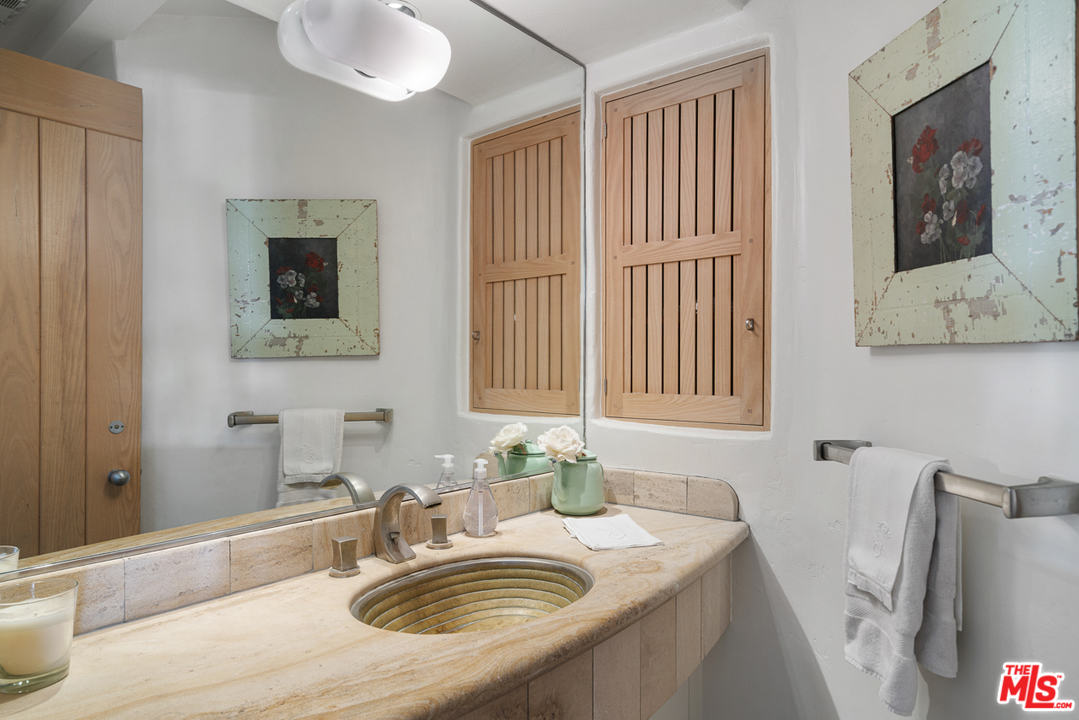 31725 Sea Level Drive Malibu, CA 90265 - Photo 16 of 37 a bathroom with a granite countertop sink a mirror and a shower