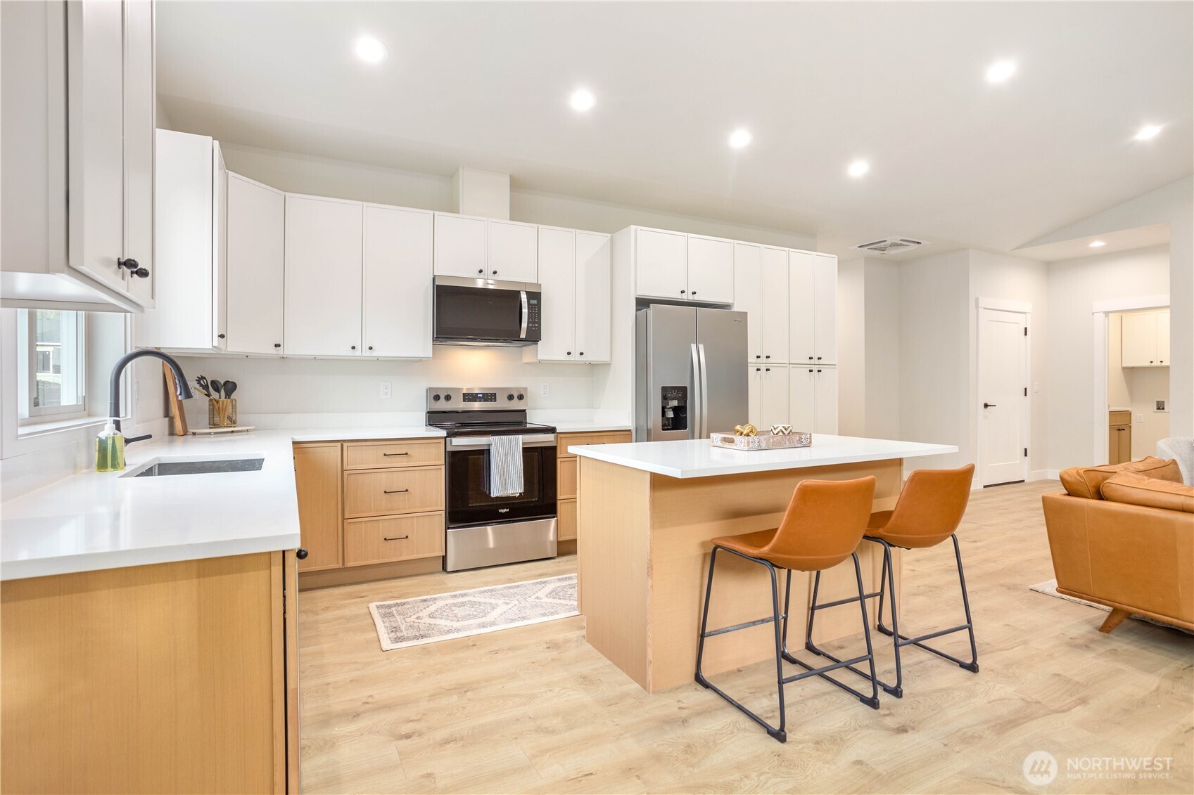 7933 Oregon Trail Maple Falls, WA 98266 - Photo 5 of 29 a kitchen with stainless steel appliances kitchen island granite countertop a sink a stove a refrigerator cabinets and a dining table with wooden floor