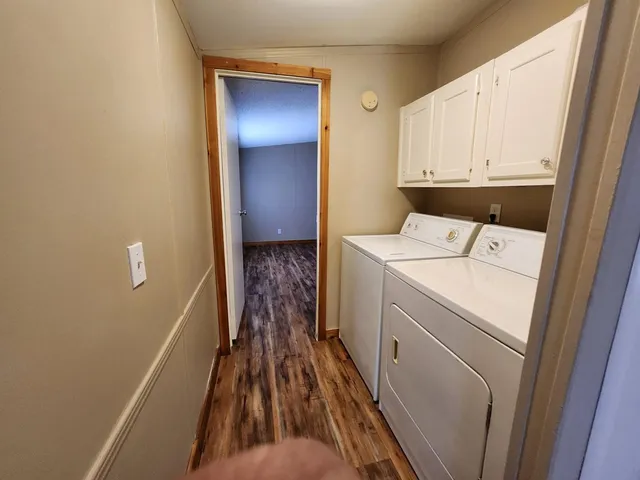 a view of an empty room with wooden floor and a ceiling fan