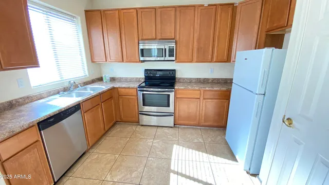 a kitchen with stainless steel appliances granite countertop a stove a sink and a refrigerator