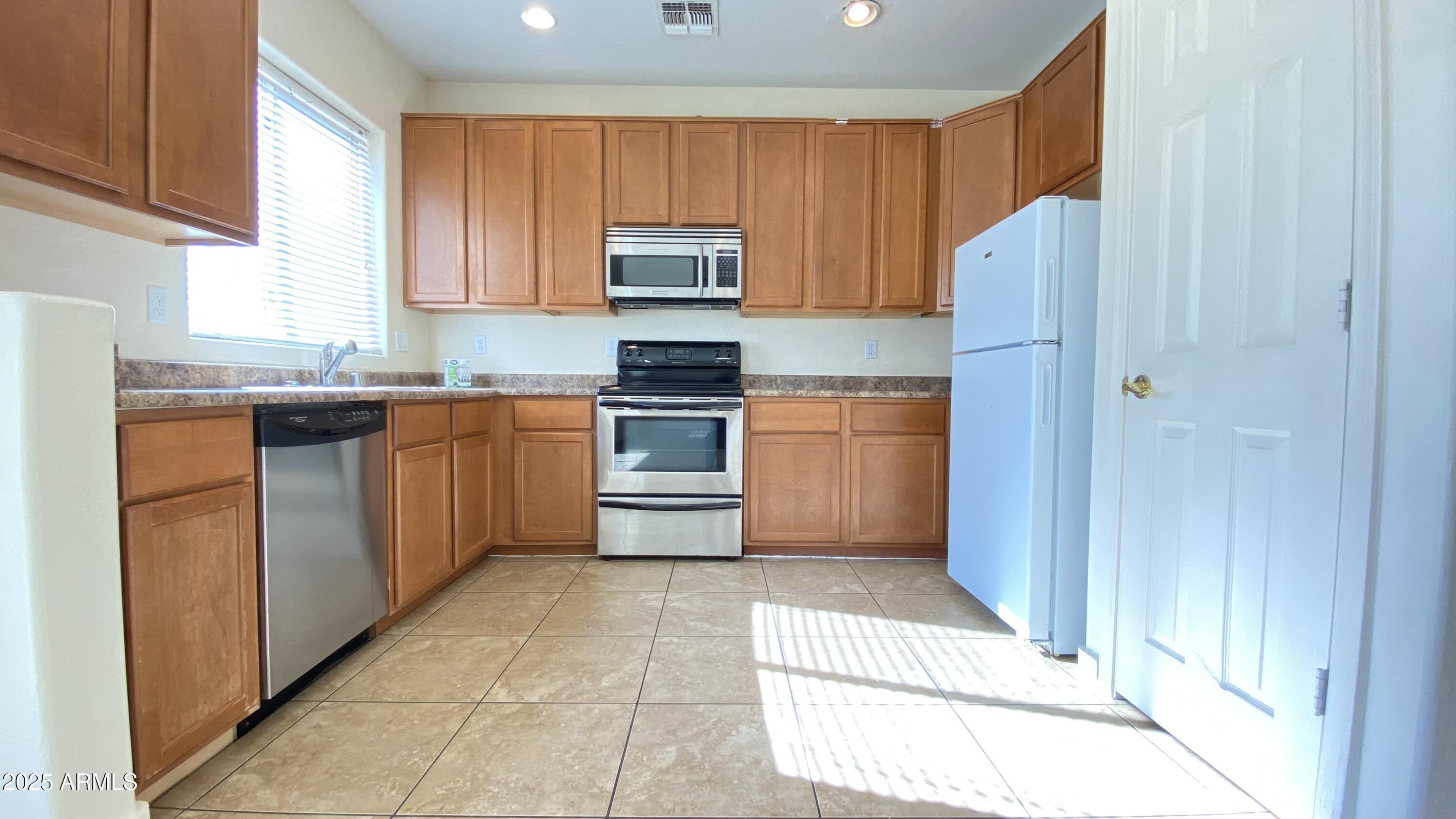 7425 West Crown King Road Phoenix, AZ 85043 - Photo 9 of 27 a kitchen with stainless steel appliances granite countertop a refrigerator and a stove top oven