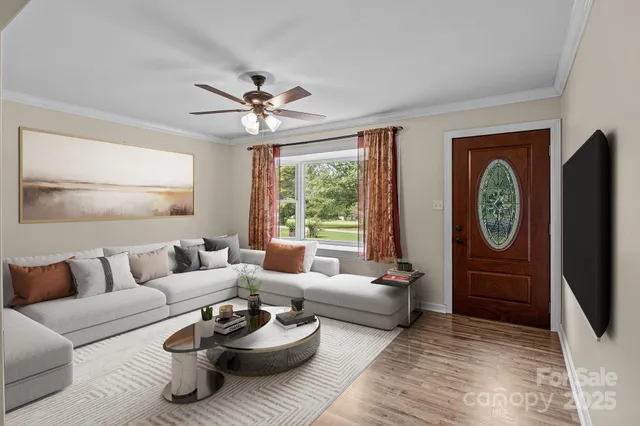 a living room with furniture a window and a flat screen tv