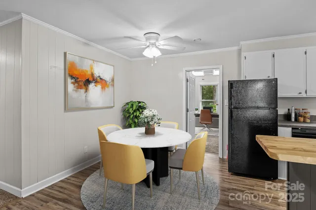 a kitchen with stainless steel appliances granite countertop a dining table and chairs