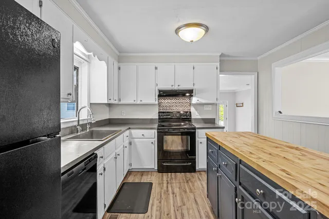 a kitchen with granite countertop a sink stainless steel appliances and cabinets