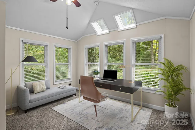 an empty room with windows and a ceiling fan
