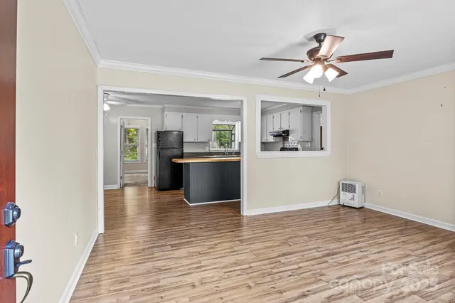 a view of a kitchen with wooden floor and a ceiling fan