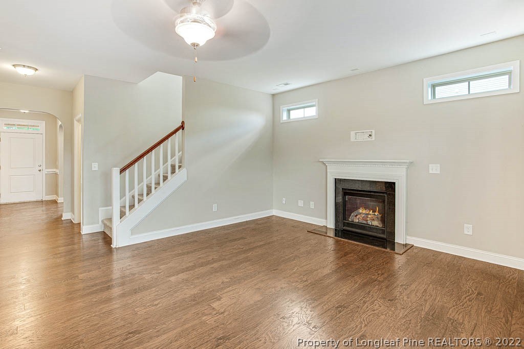 268 Turriff Way Cameron, NC 28326 - Photo 11 of 44 a view of an empty room with wooden floor fireplace and a window