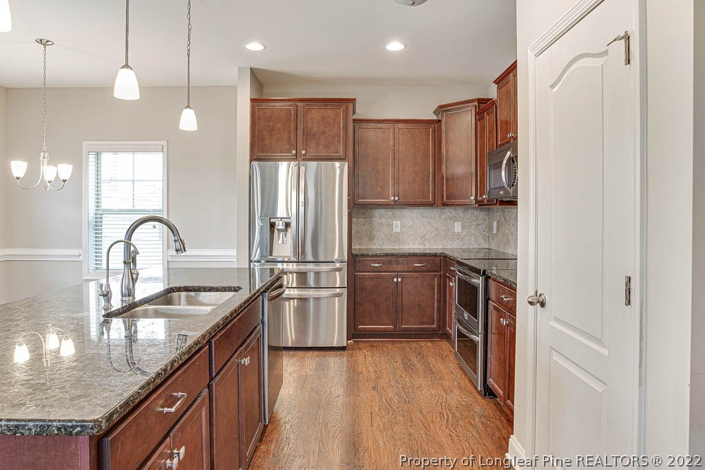 268 Turriff Way Cameron, NC 28326 - Photo 14 of 44 a kitchen with stainless steel appliances granite countertop a sink stove and refrigerator