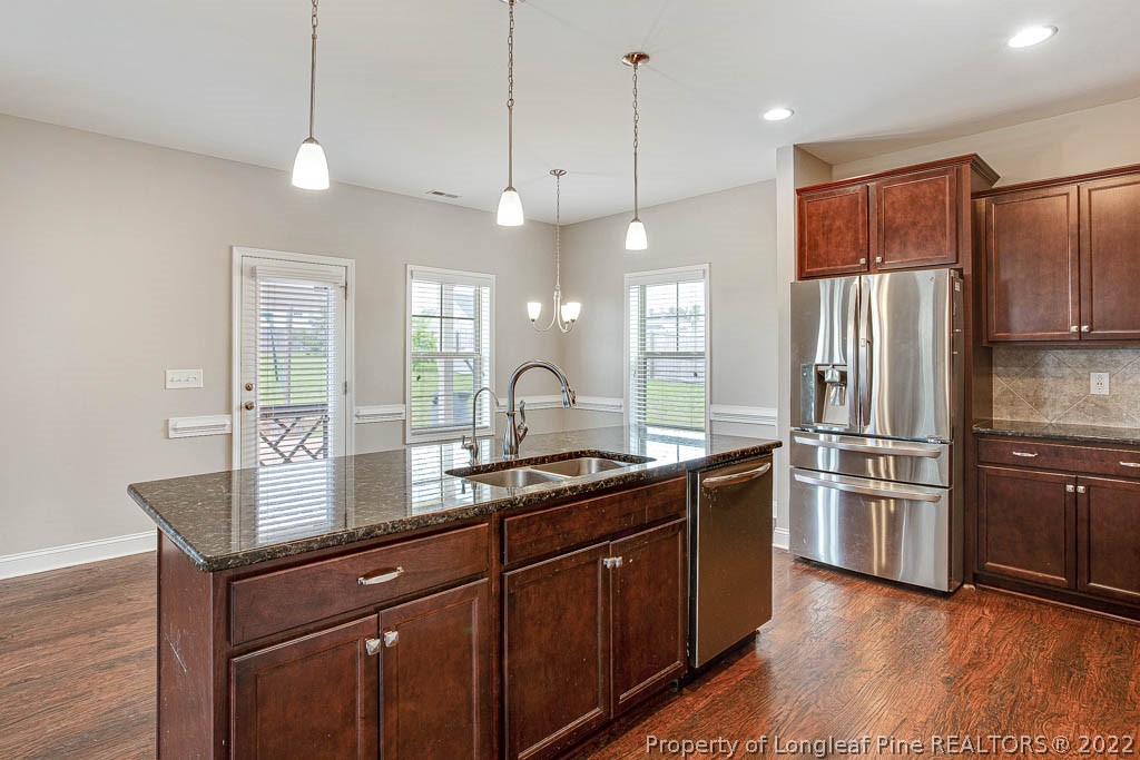 268 Turriff Way Cameron, NC 28326 - Photo 15 of 44 a kitchen with kitchen island granite countertop stainless steel appliances and wooden cabinets