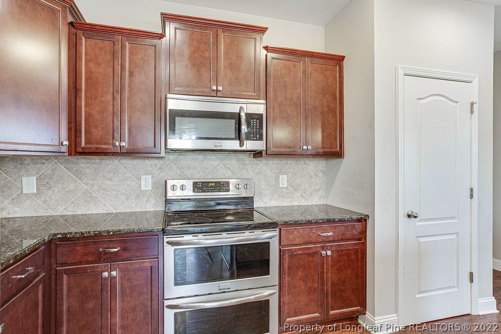 268 Turriff Way Cameron, NC 28326 - Photo 16 of 44 a kitchen with granite countertop wooden cabinets and stainless steel appliances