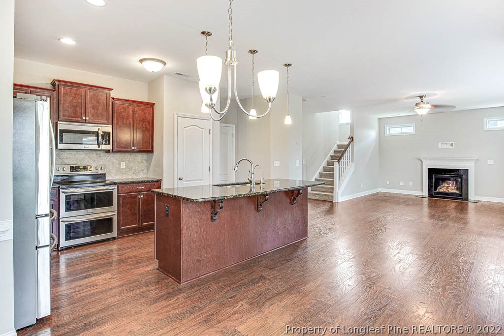 268 Turriff Way Cameron, NC 28326 - Photo 18 of 44 a kitchen with stainless steel appliances kitchen island granite countertop a stove a refrigerator a sink a oven and a wooden floor