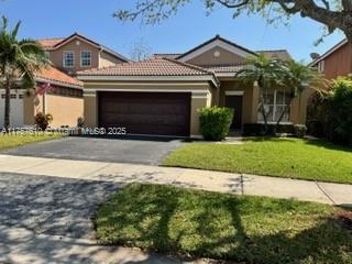 959 Falling Water Road Weston, FL 33326 - Photo 1 of 24 a front view of a house with a yard and garage