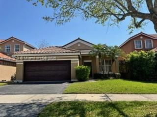 959 Falling Water Road Weston, FL 33326 - Photo 2 of 24 a front view of a house with a garden and yard