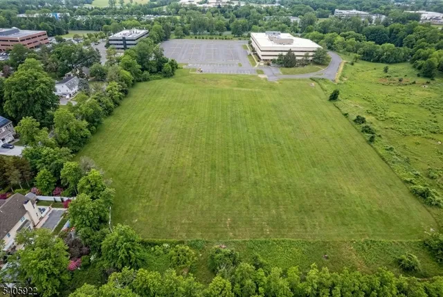 an aerial view of residential houses with outdoor space and trees