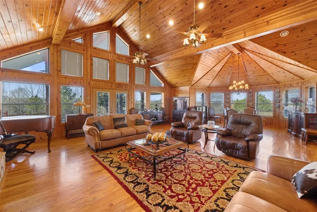 a living room with furniture a couch and large windows