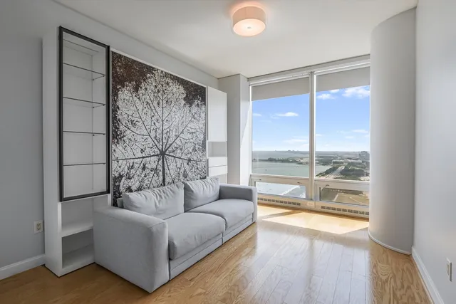 a living room with furniture and a large window with wooden floor