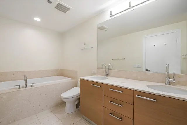 a bathroom with a granite countertop sink a toilet and a bathtub