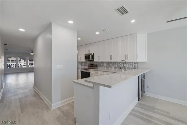 a kitchen with stainless steel appliances granite countertop a sink and a refrigerator