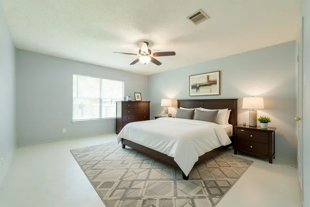 a spacious bedroom with a bed and a chandelier